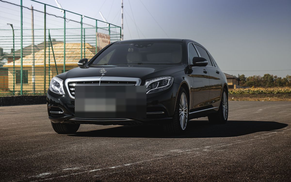 A black full-size luxury sedan, photographed front three-quarter
